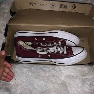 Burgundy low top converses.